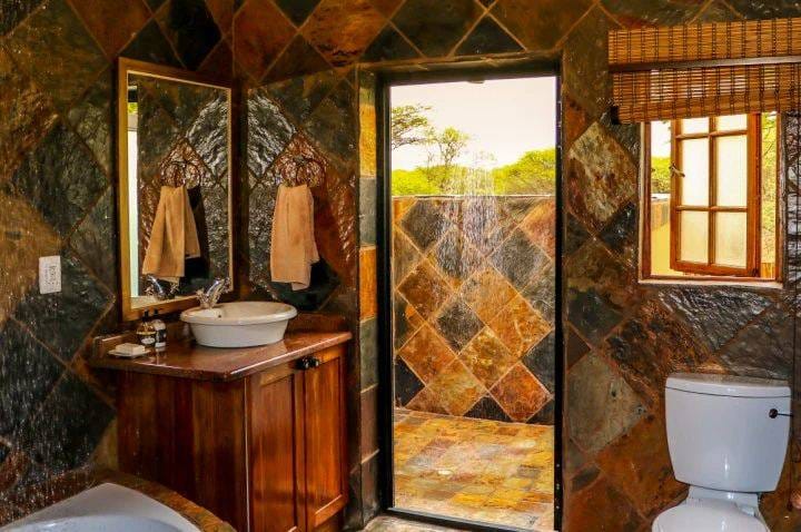 Slate-tiled ensuite bathroom with outdoor shower