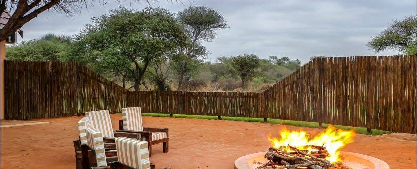 Open-air boma with fire pit and lounge chairs